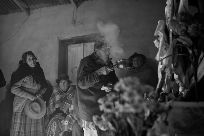 Entre voces sigilosas, flores y copal avanza la noche. Los devotos contemplan con cariño las vestimentas de las cruces (cruces de Milagro).