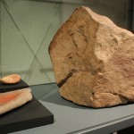 a) Bloque con pictografía estilo El Médano,cetáceo con balsero. Pescadores Tardíos. Colección Museo Augusto Capdeville, Taltal. b) Mortero y mano de moler con pigmento rojo.Piedra y óxido de fierro. Costa de Taltal. Pescadores Tempranos f Tardíos. Colección Museo Augusto Capdeville, Taltal.
