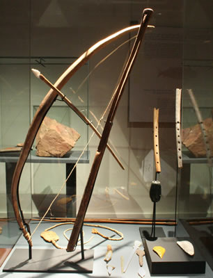 a) Estólica: Lanza-dardos .Madera y gancho de hueso. Costa de Taltal – Pescadores Tempranos. Colección Museo Augusto Capdeville. b) Arco y astiles.Madera,tendón y piedra. Costa de lquique. Pescadores Tardíos 1000 – 1400 d.C. Colección Museo Regional de lquique.