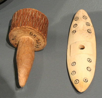 a) Flotador o tapón de vasija. Madera. Costa de !quique. Pescadores Tardíos 1000 -1400 d.C. Colección Museo Regional de !quique. b) Volante o tortera de huso textil. Hueso. Costa de Taltal. Cultura San Pedro o Diaguita 1000 – 1400 d.C. Colección Museo Augusto Capdeville , Taltal.