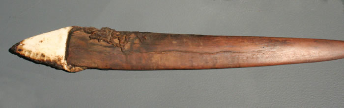 Cuchillo enmangado con restos de tejido y estera . Madera y sílice. Costa de lquique – Pescadores Tempranos . Complejo Chinchorro 5500 – 2000 a.c. Colección Museo Regional de lquique.
