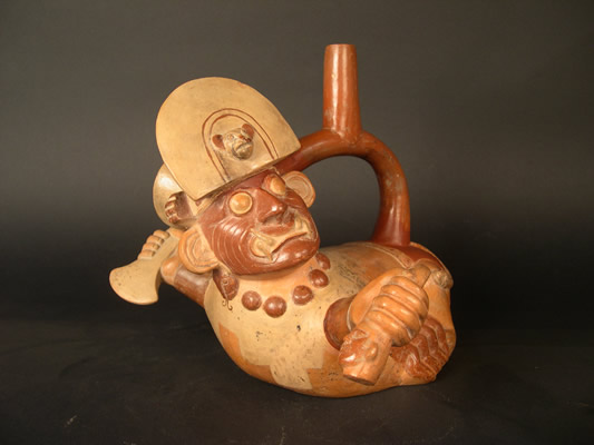 Botella asa-estribo: «Cara Ar rugada» con patas de crustáceo sosteniendo cuchillo y cabeza Decapitada. Museo Larco, Lima – Perú
